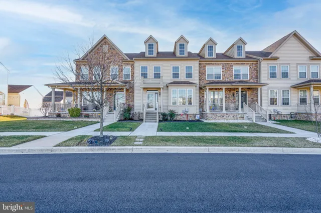a view of a big building next to a yard with large trees