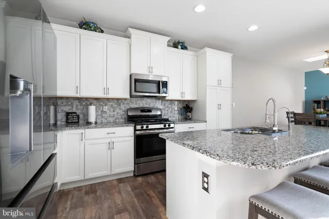 a kitchen with stainless steel appliances granite countertop a stove a sink dishwasher and a refrigerator