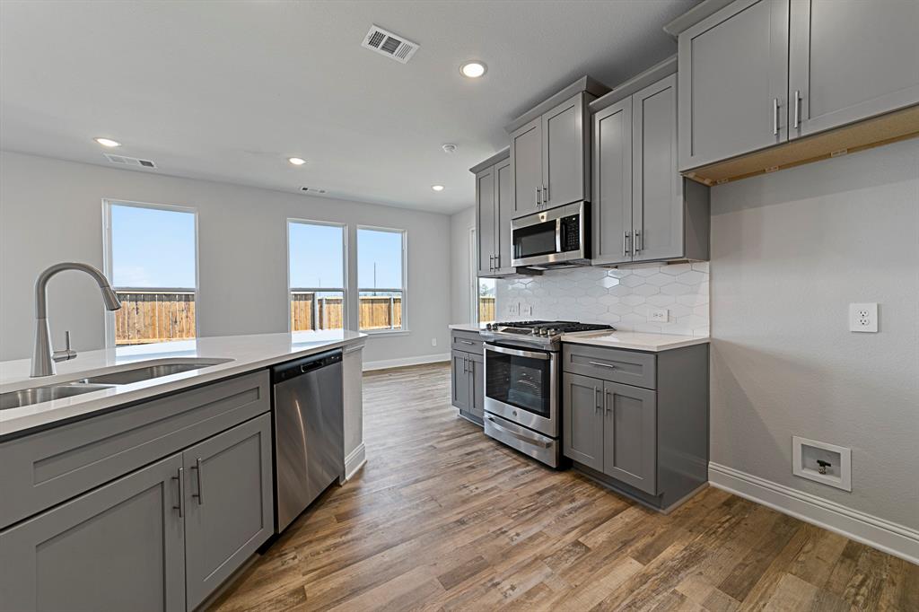 11231 Chimes Street Frisco, TX 75035 - Photo 2 of 5 a kitchen with sink a microwave and cabinets