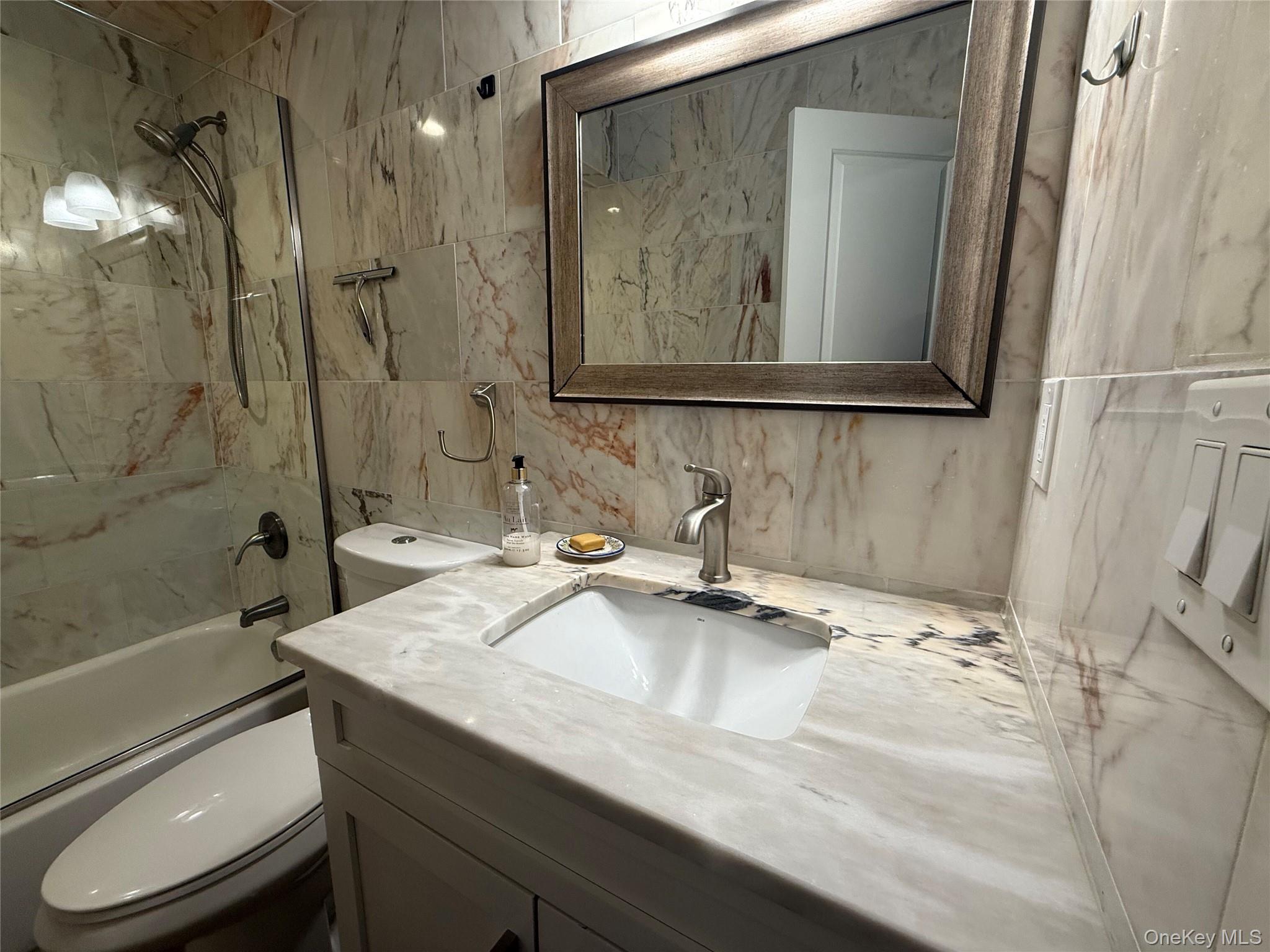 125 Main Street, Unit 2A Ossining, NY 10562 - Photo 16 of 23 a bathroom with a granite countertop sink toilet and shower