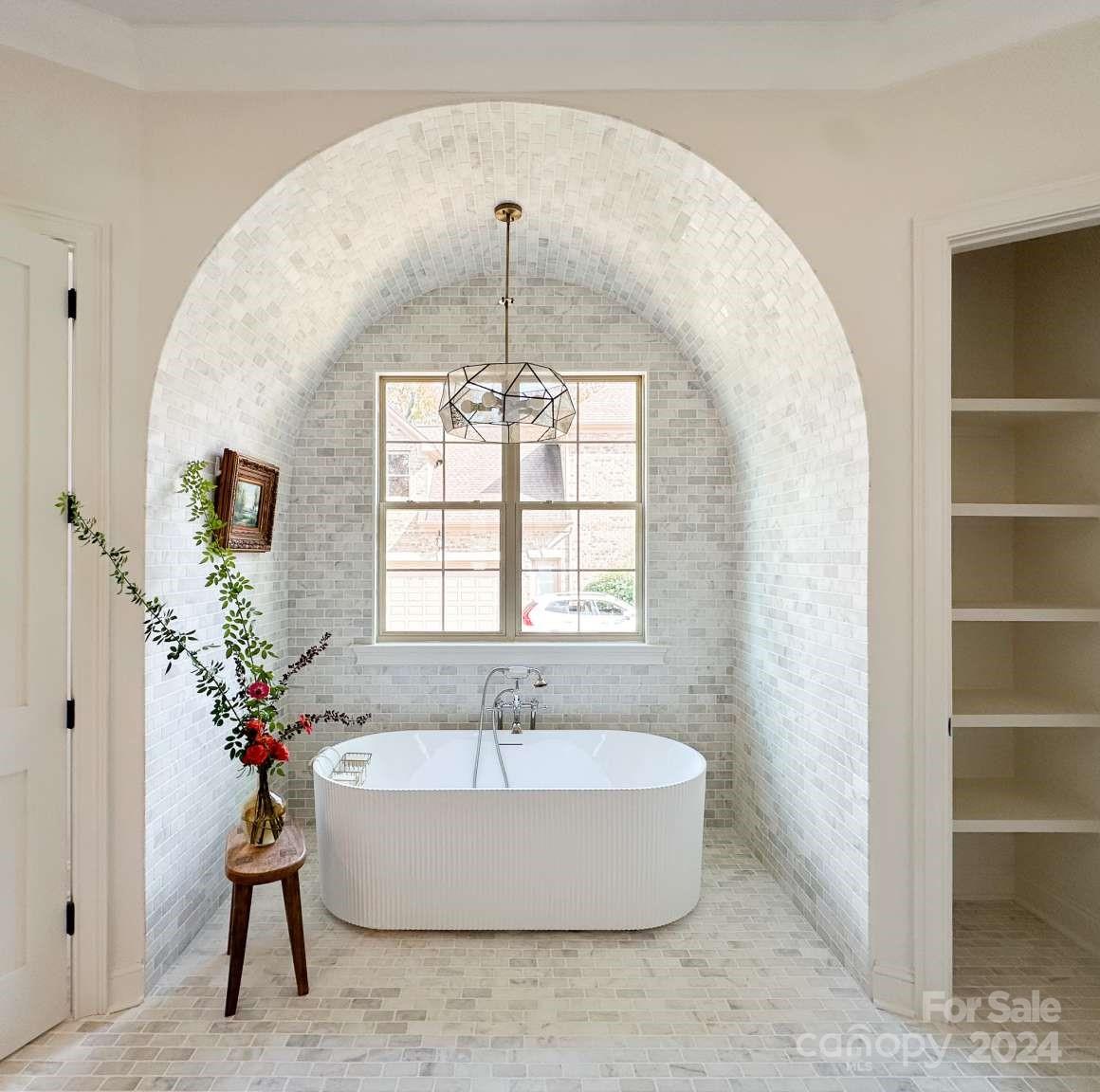 8316 Rolling Fields Road Charlotte, NC 28227 - Photo 23 of 35 a spacious bathroom with a tub and chandelier