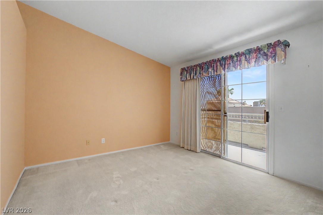 2243 Rugged Mesa Drive Laughlin, NV 89029 - Photo 16 of 32 A spacious room with a vaulted ceiling and sliding glass doors leading to the outdoors.