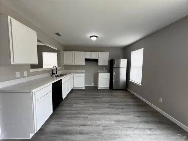 a large kitchen with stainless steel appliances granite countertop a stove a sink dishwasher and a refrigerator