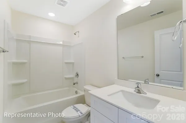 a bathroom with a granite countertop sink a toilet and shower
