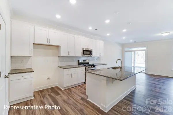 a kitchen with stainless steel appliances granite countertop a stove a sink and a refrigerator