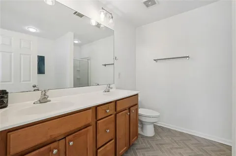 a bathroom with a double vanity sink toilet and mirror