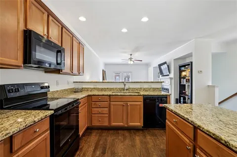 a kitchen with stainless steel appliances granite countertop wooden cabinets and a stove top oven