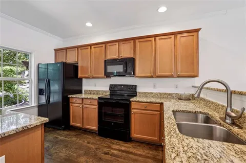 a kitchen with stainless steel appliances granite countertop a refrigerator stove and sink