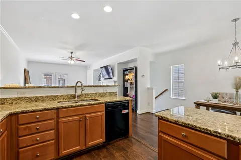 a kitchen with granite countertop kitchen island a sink and a stove with wooden floor