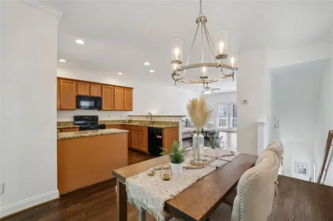 a view of a dining room and livingroom with furniture wooden floor a chandelier