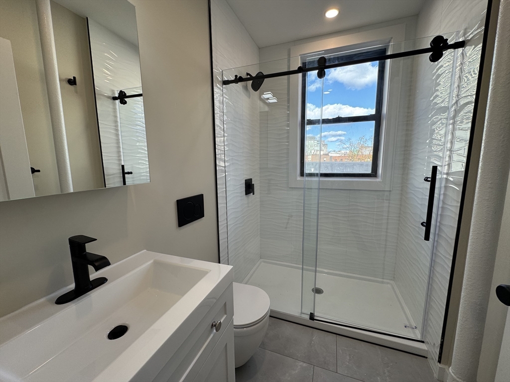 41 Edgerly Road, Unit 22 Boston, MA 02115 - Photo 6 of 13 a bathroom with a sink toilet and shower