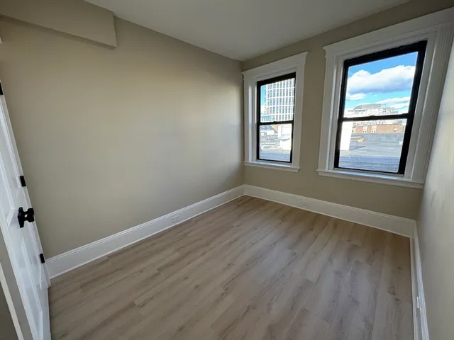 an empty room with wooden floor and entrance