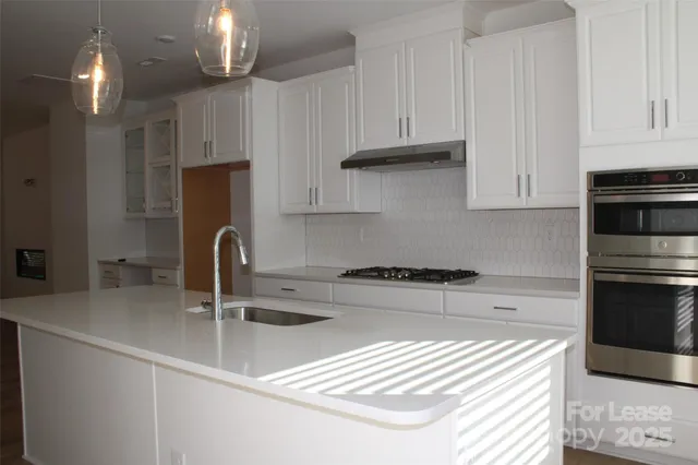 a kitchen with stainless steel appliances granite countertop a sink refrigerator and cabinets