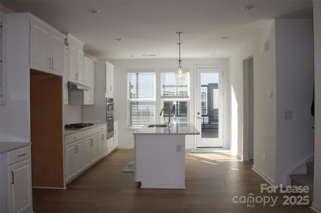 a kitchen with stainless steel appliances kitchen island granite countertop a refrigerator and a stove top oven