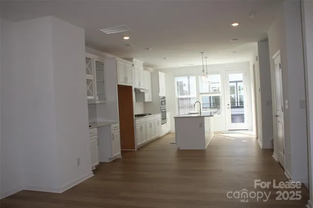 a kitchen with stainless steel appliances a refrigerator and wooden floor