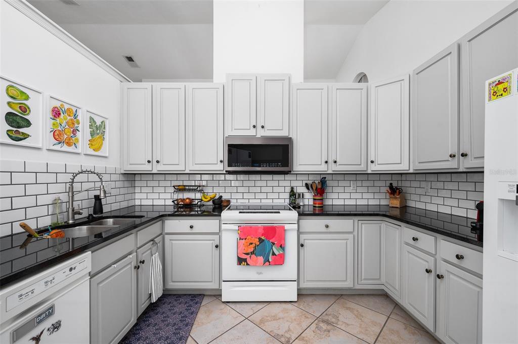 5154 Southwest 88 Terrace Gainesville, FL 32608 - Photo 11 of 29 a kitchen with stainless steel appliances granite countertop white cabinets sink and dishwasher