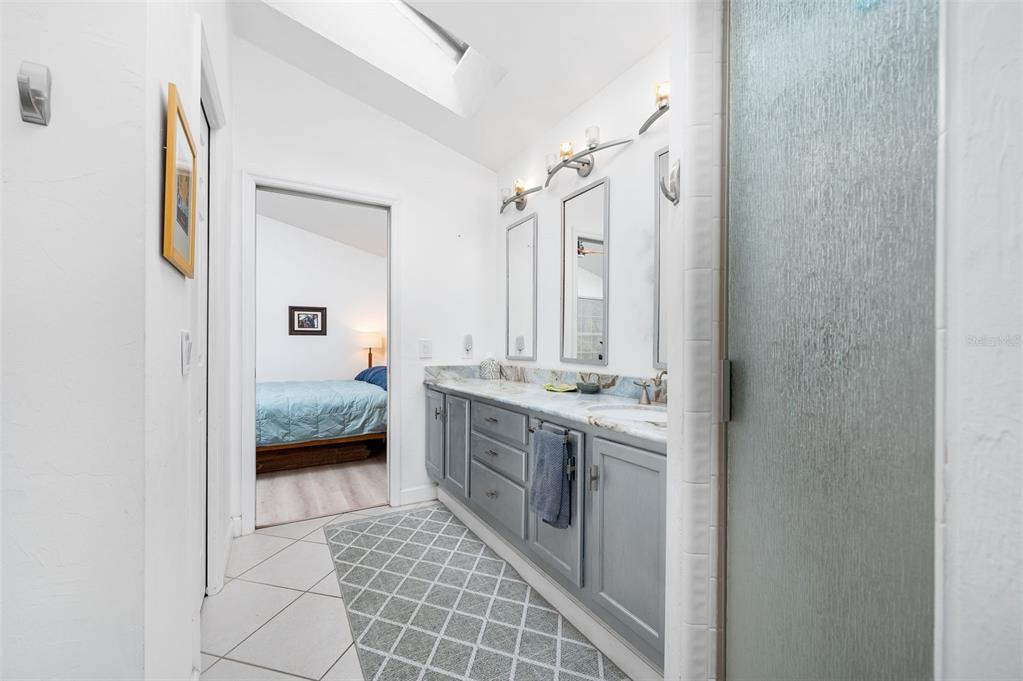 5154 Southwest 88 Terrace Gainesville, FL 32608 - Photo 20 of 29 a spacious bathroom with a double vanity sink a mirror and a bathtub