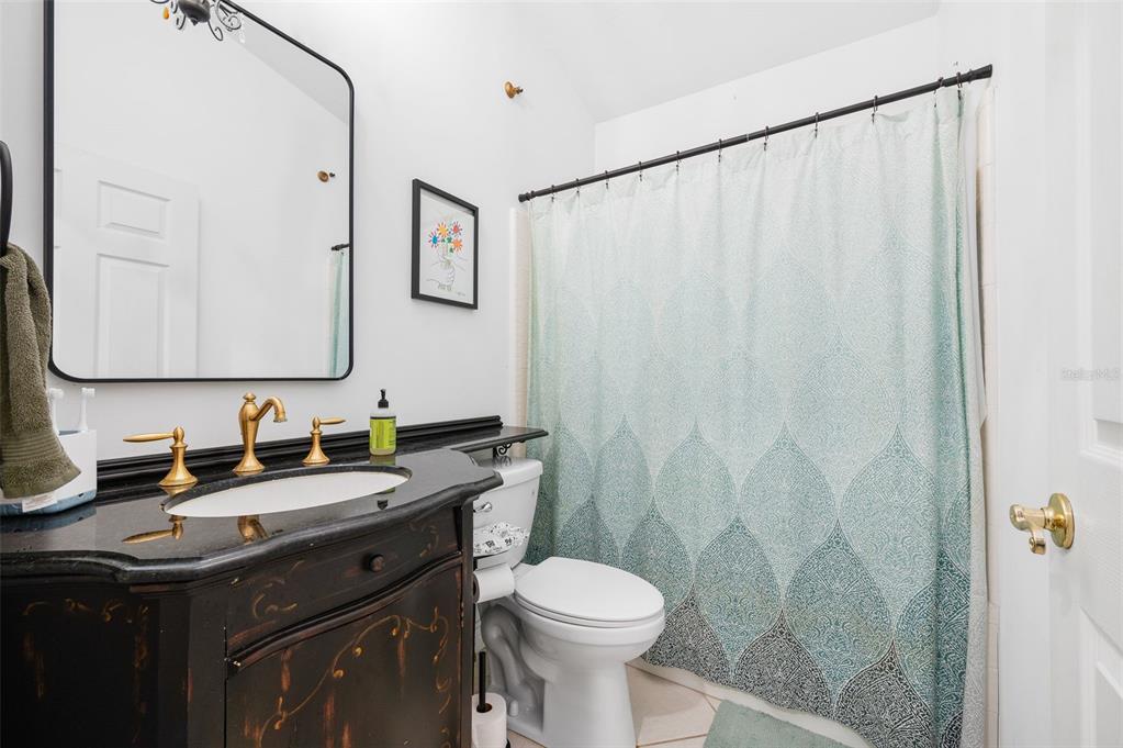 5154 Southwest 88 Terrace Gainesville, FL 32608 - Photo 26 of 29 a bathroom with a granite countertop sink toilet and a mirror