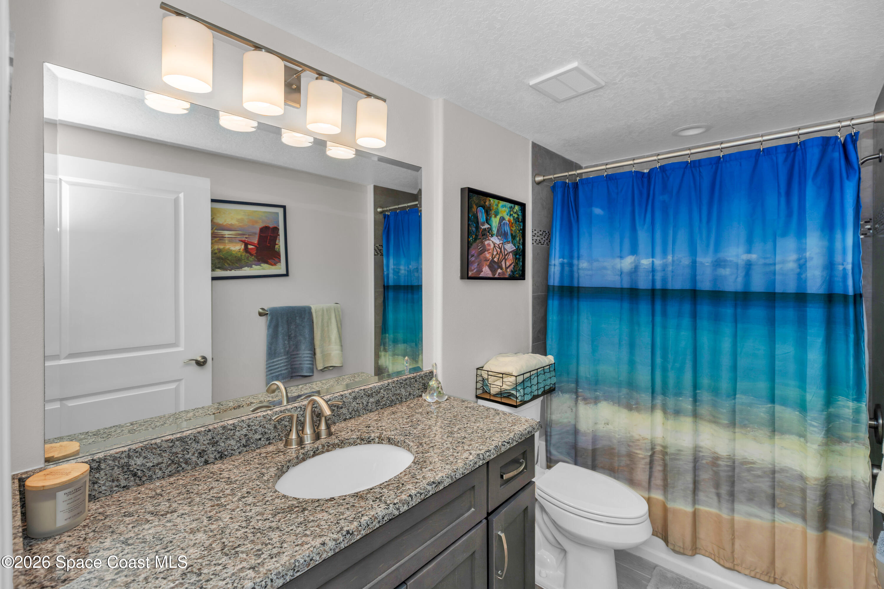 1805 Riverside Drive, Unit 506 Titusville, FL 32780 - Photo 16 of 24 a bathroom with a granite countertop sink toilet and a mirror