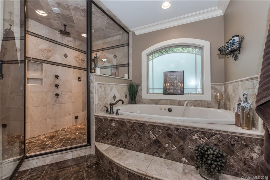 10023 Bora Bora Drive Tega Cay, SC 29708 - Photo 18 of 32 a bathroom with a tub sink and mirror