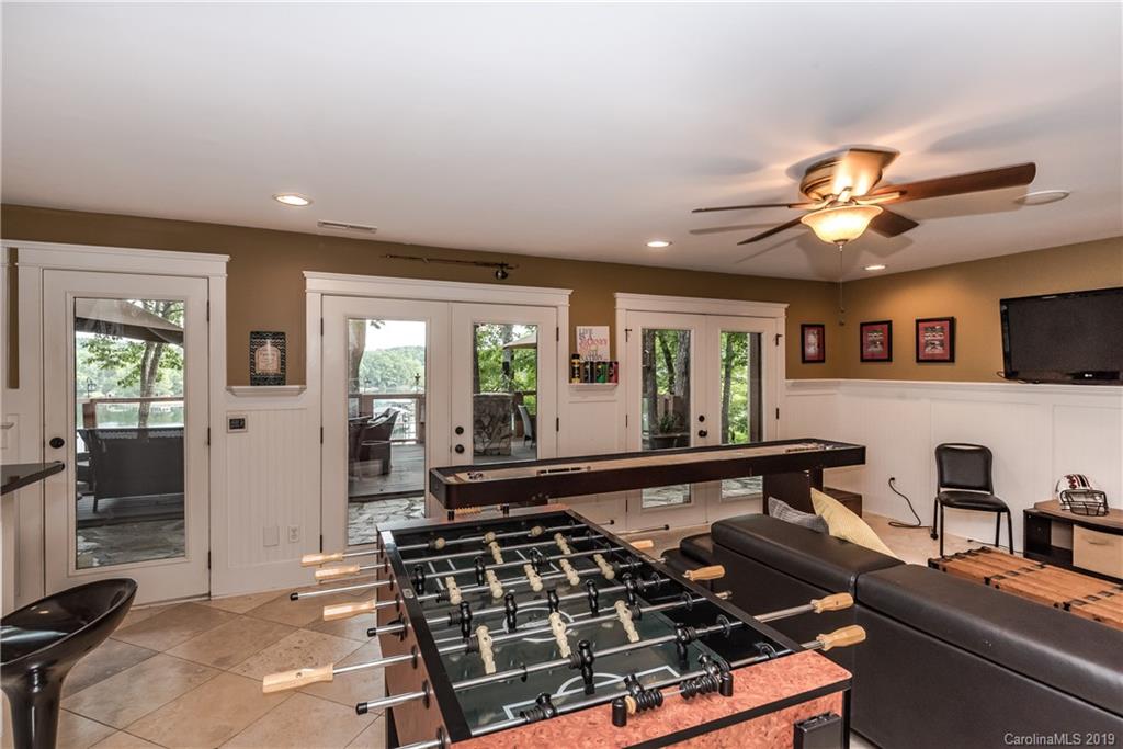 10023 Bora Bora Drive Tega Cay, SC 29708 - Photo 23 of 32 a living room with furniture a flat screen tv and a large window