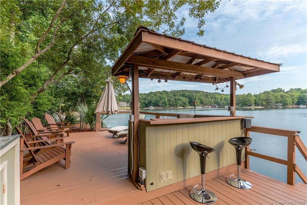 10023 Bora Bora Drive Tega Cay, SC 29708 - Photo 29 of 32 a view of a patio with table and chairs under an umbrella with a small yard
