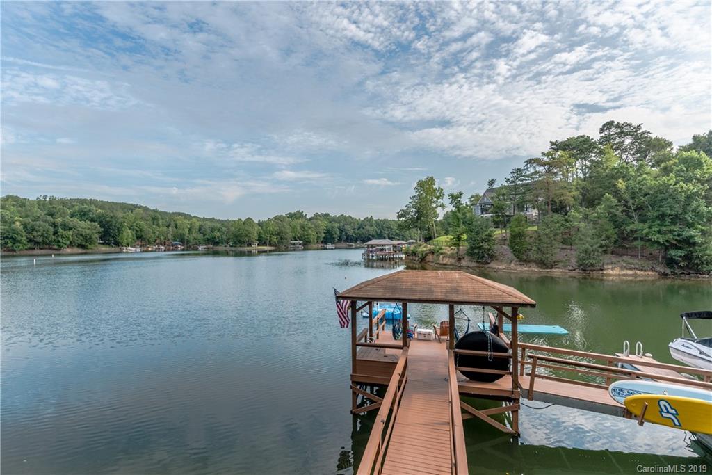 10023 Bora Bora Drive Tega Cay, SC 29708 - Photo 4 of 32 a view of a lake with a table and chairs under an umbrella