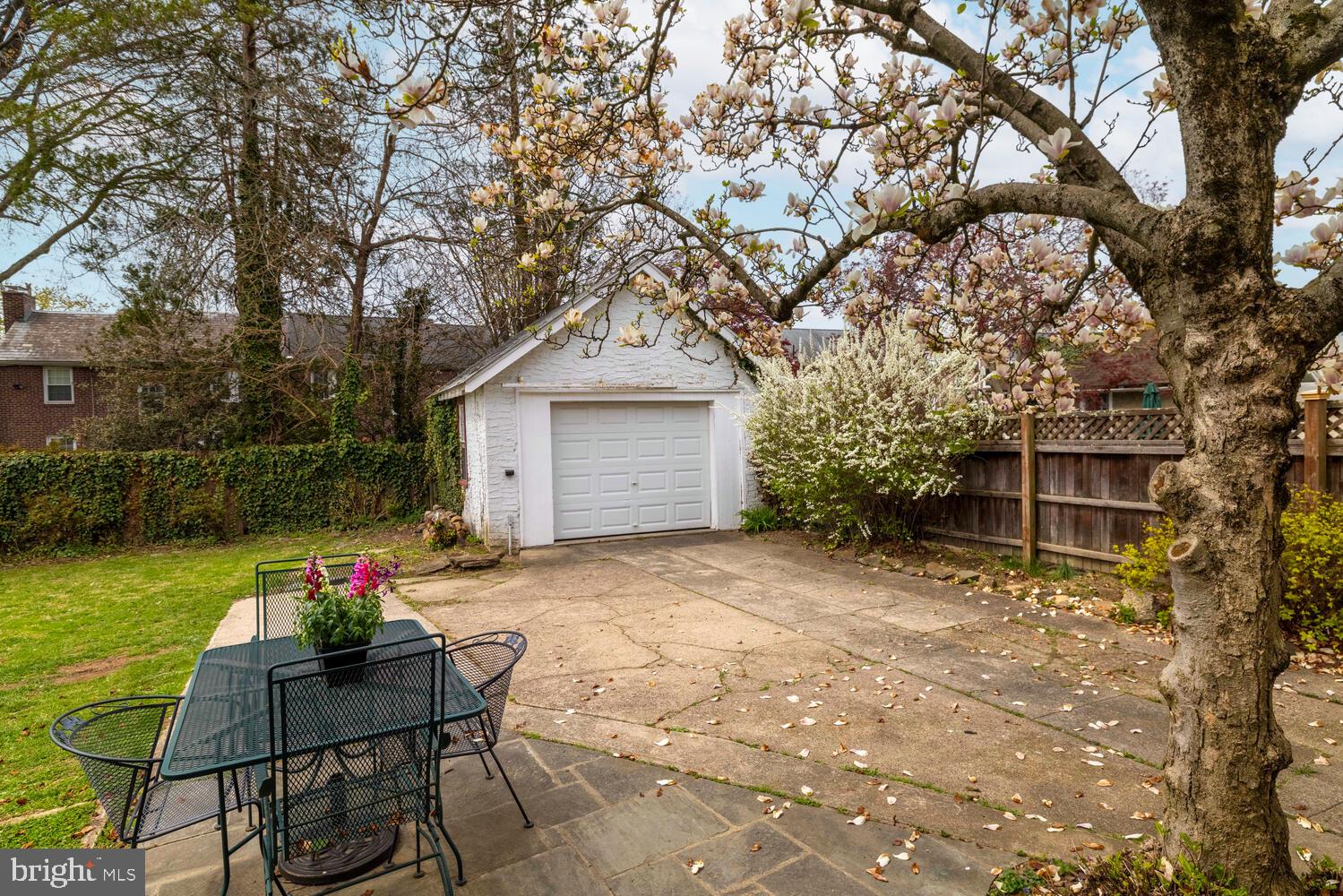2116 East County Line Road Ardmore, PA 19003 - Photo 37 of 38 a backyard of a house with table and chairs and a large tree