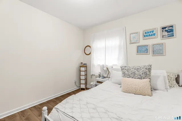 a bedroom with a bed and painting on the wall