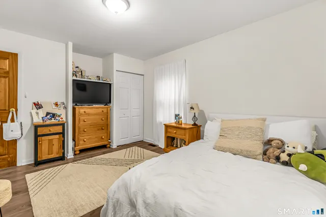 a bedroom with a bed and a flat tv screen in it