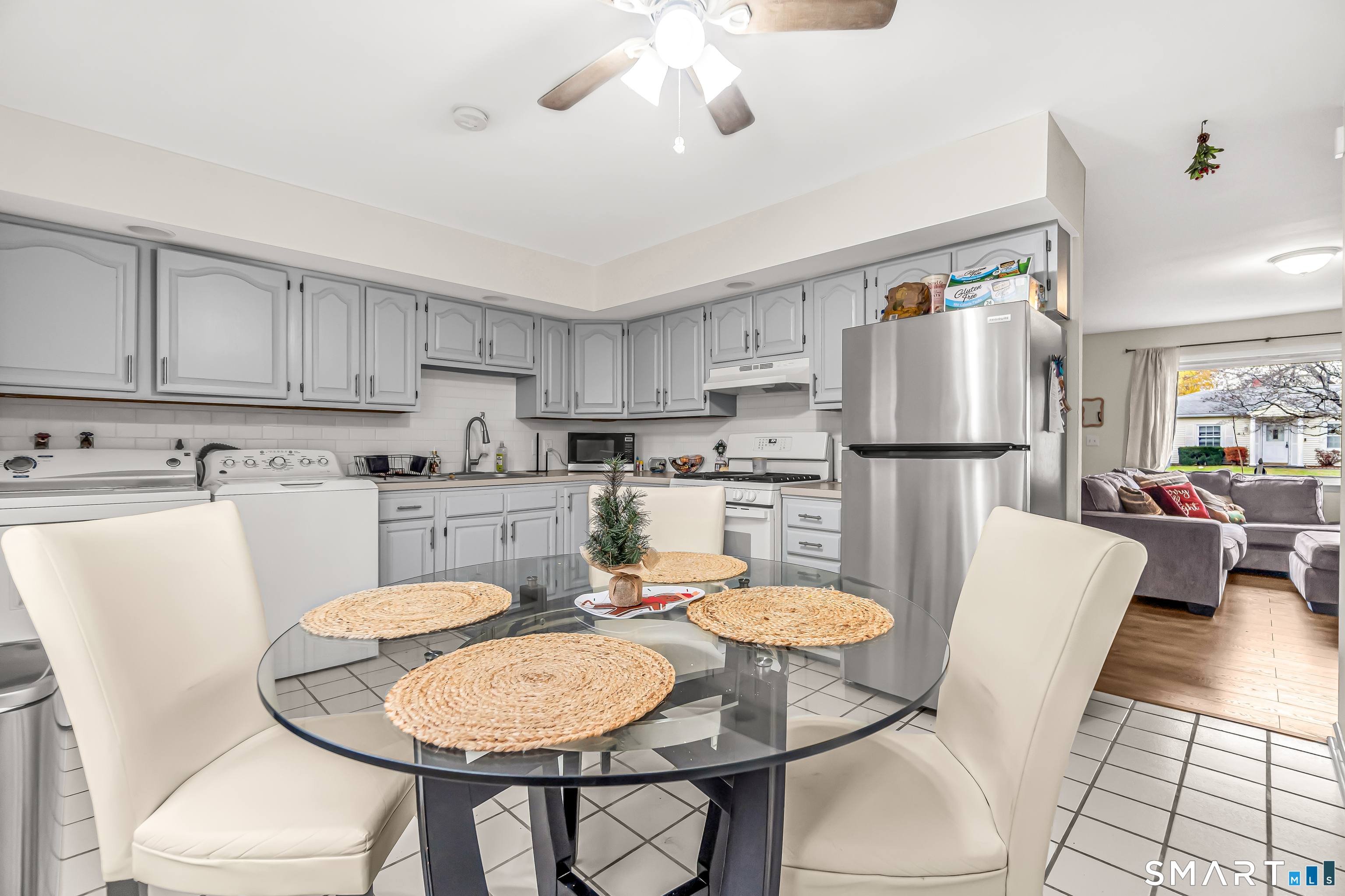252 Bear Paw Road Bridgeport, CT 06606 - Photo 4 of 25 a kitchen with stainless steel appliances granite countertop a dining table chairs and white cabinets
