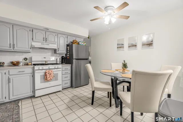a kitchen with a white cabinets and chairs