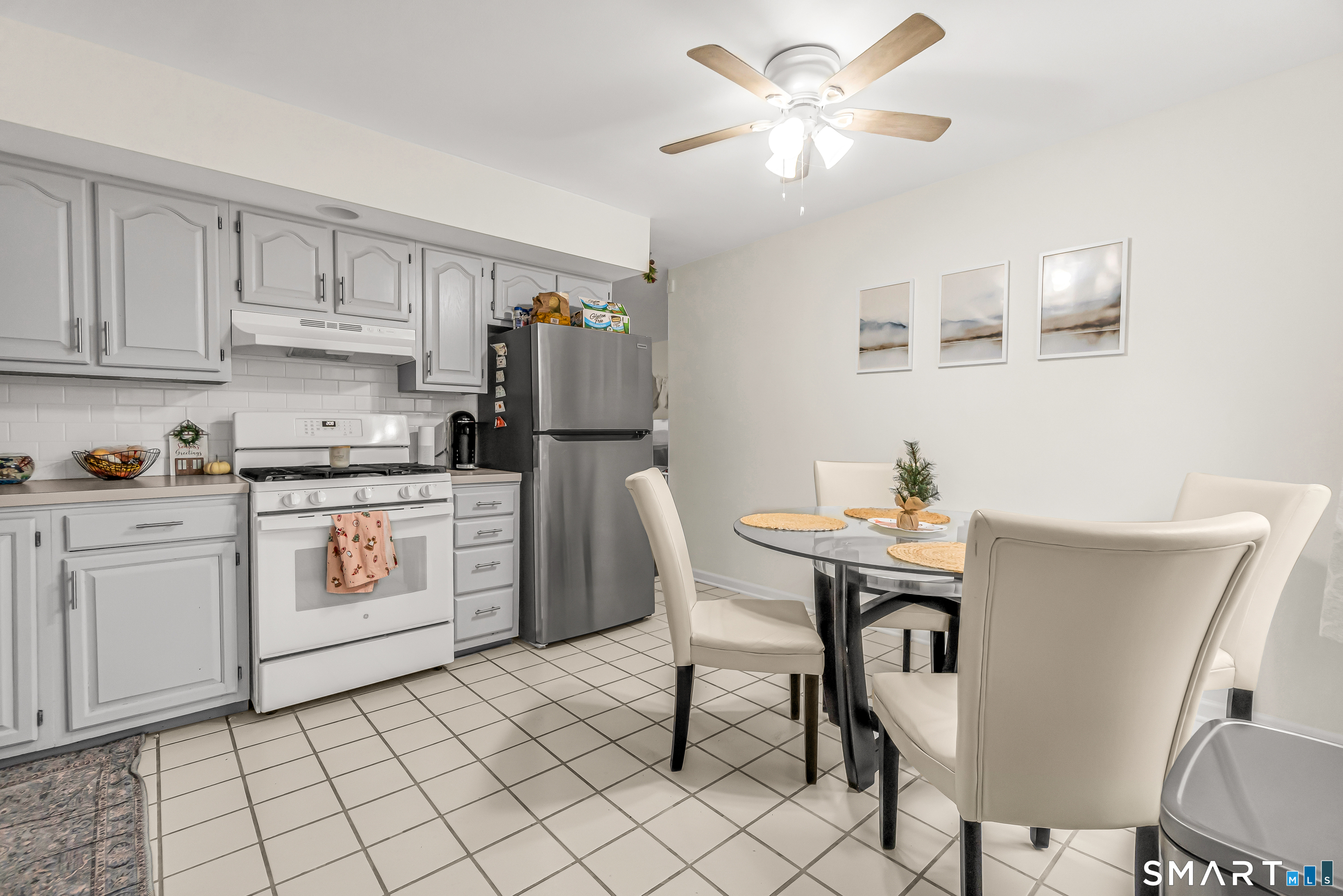 252 Bear Paw Road Bridgeport, CT 06606 - Photo 6 of 25 a kitchen with a white cabinets and chairs