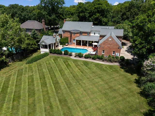 a view of a house with pool and chairs under an umbrella