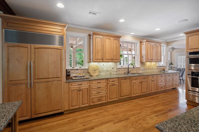 a view of a hallway with wooden floor and a bathroom