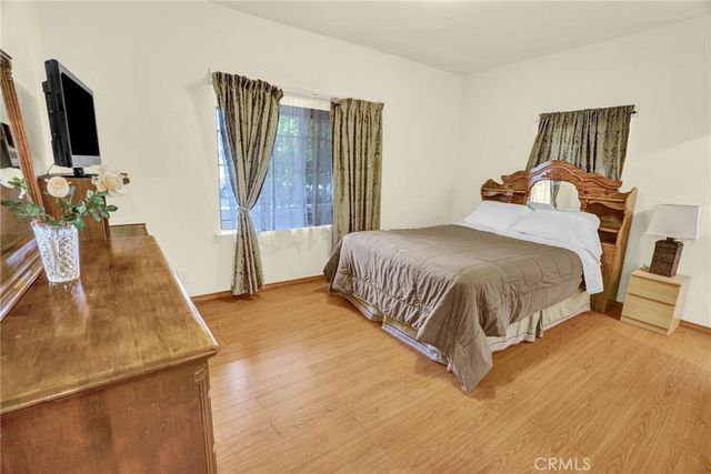 a bedroom with a bed and a flat tv screen on a dresser