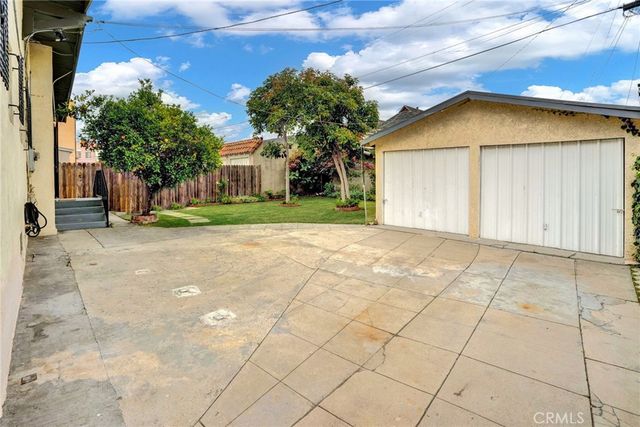 a view of a house with a yard and potted plants