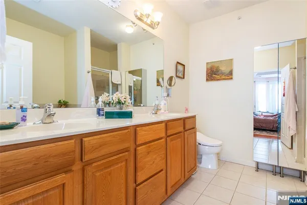 a bathroom with a double vanity sink toilet and a mirror