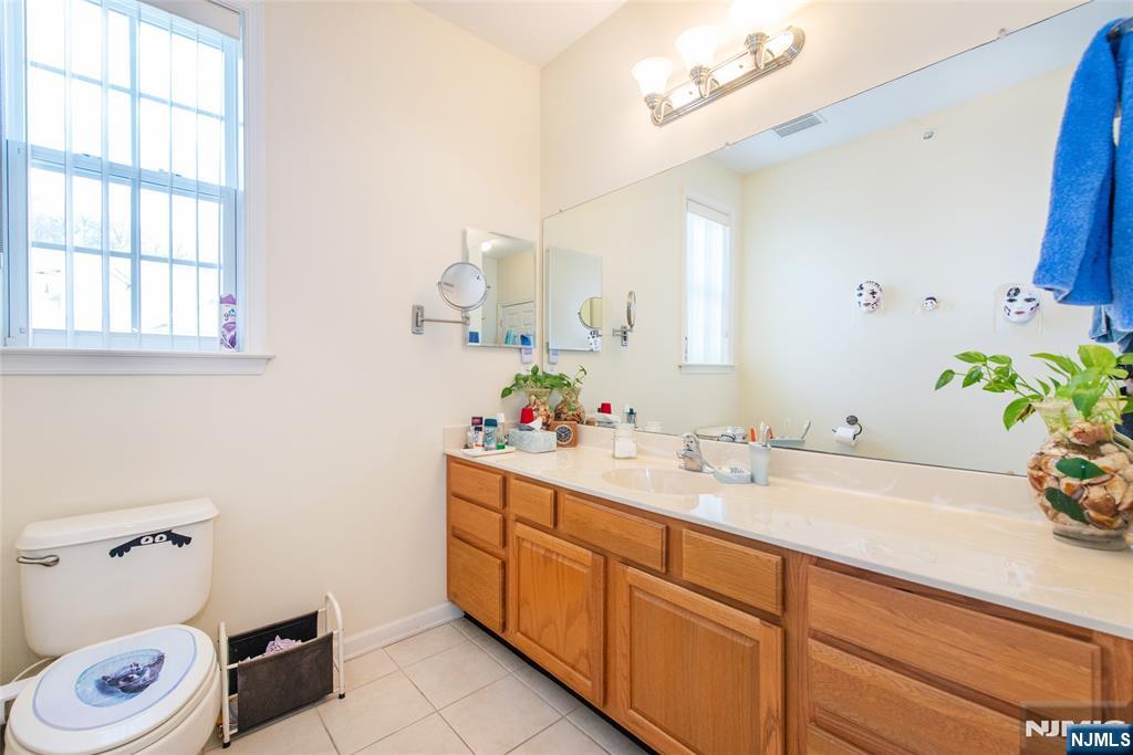 9 Cliff Road Woodland Park, NJ 07424 - Photo 10 of 25 a bathroom with a sink a toilet and a mirror