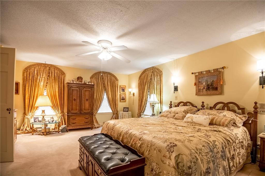 1355 Yahres Road Sharon, PA 16146 - Photo 29 of 33 a spacious bedroom with a bed a couch and a chandelier