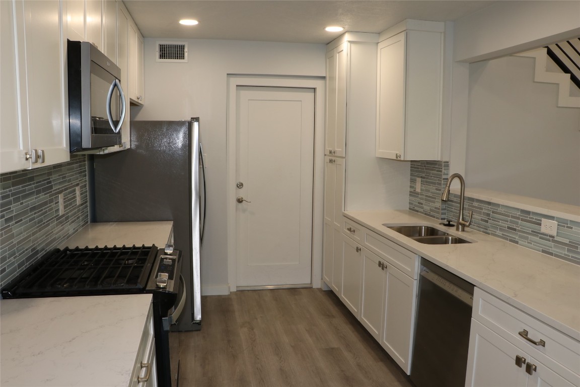 8903 Mesa Drive, Unit A Austin, TX 78759 - Photo 11 of 27 a kitchen with a sink stove and refrigerator