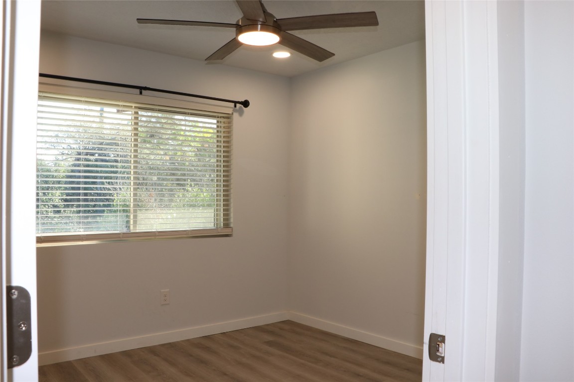 8903 Mesa Drive, Unit A Austin, TX 78759 - Photo 18 of 27 a view of an empty room with wooden floor and a window