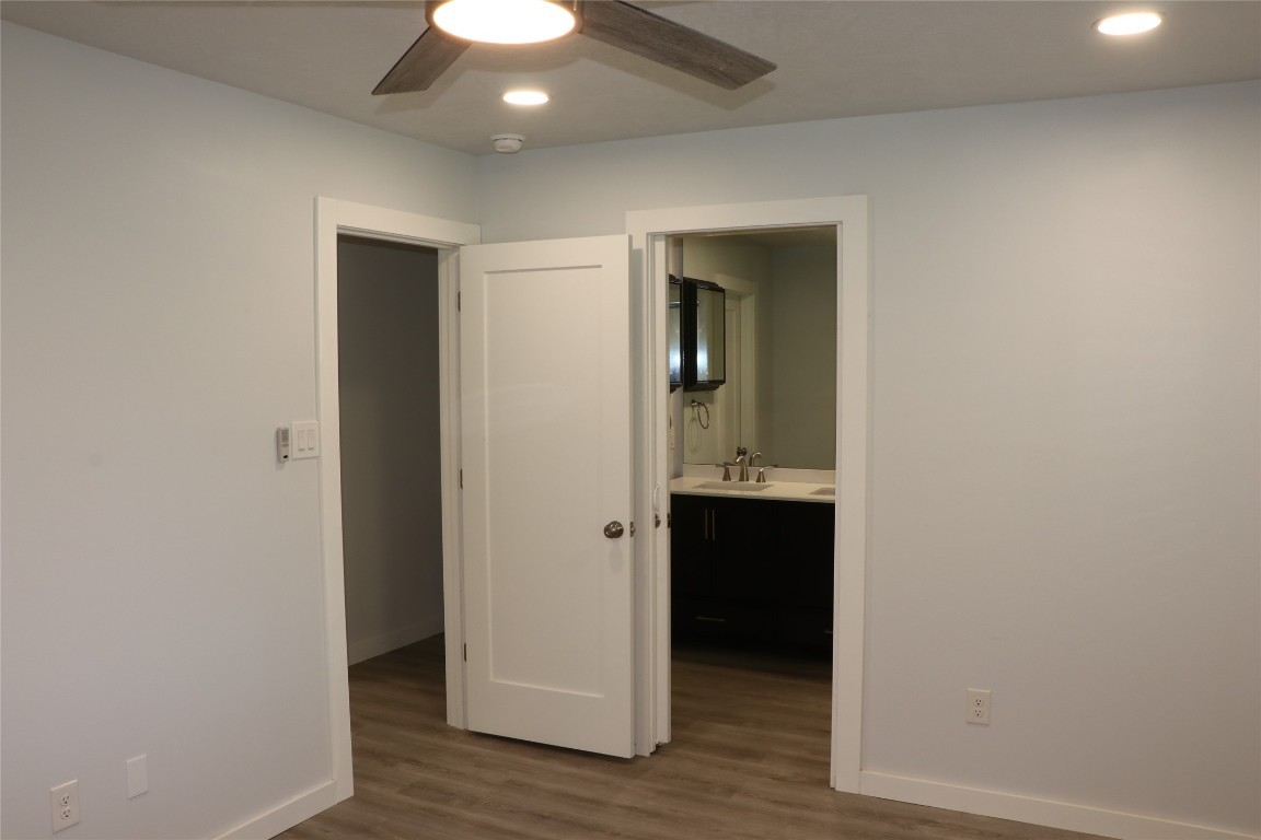 8903 Mesa Drive, Unit A Austin, TX 78759 - Photo 21 of 27 an empty room with wooden floor and cabinet