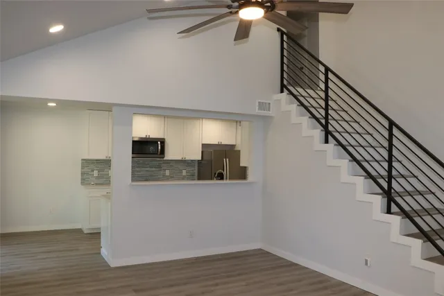 a view of a hallway with wooden floor and staircase