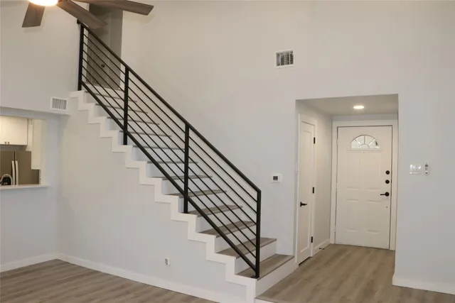 a view of staircase with wooden floor and white walls