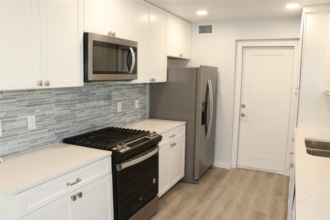8903 Mesa Drive, Unit A Austin, TX 78759 - Photo 10 of 27 a kitchen with granite countertop cabinets and steel stove top oven