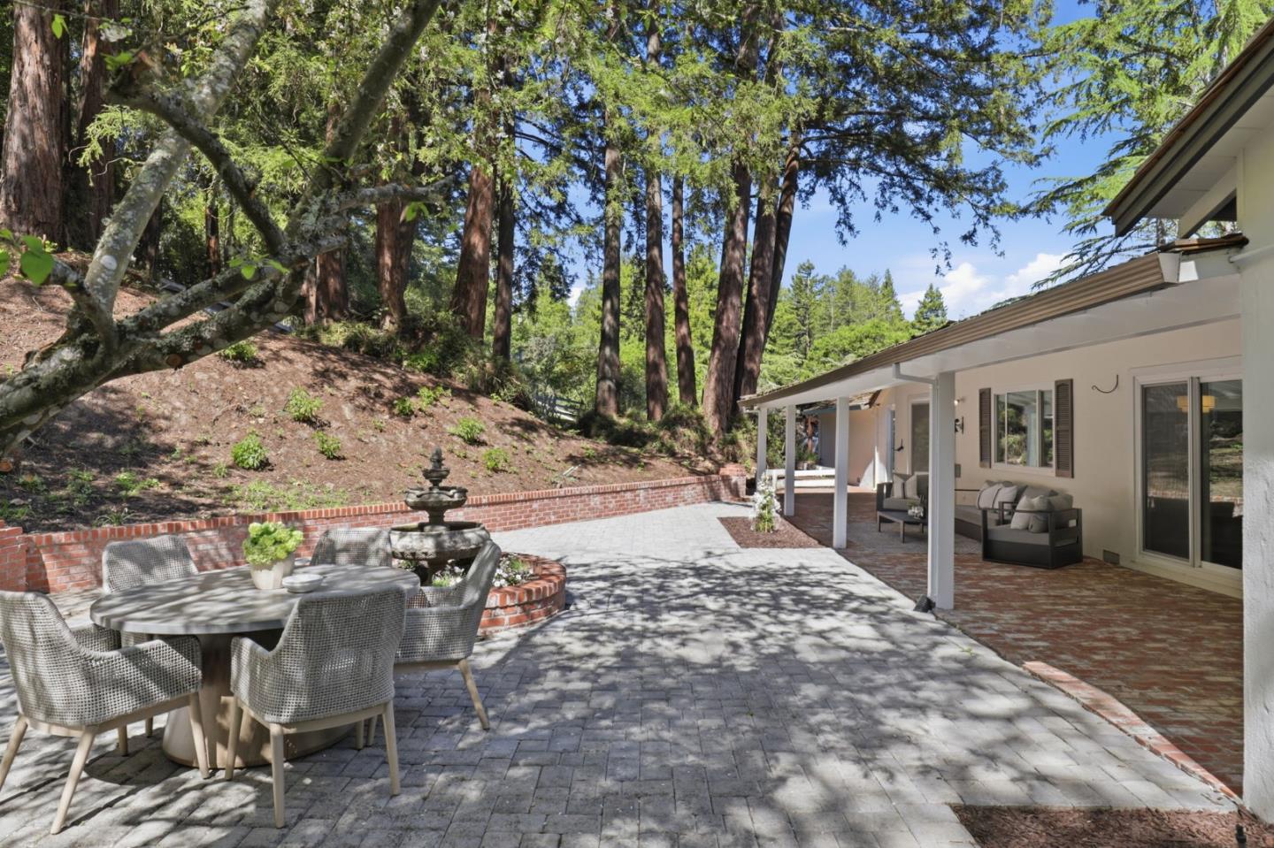 425 Summit Spring Road Woodside, CA 94062 - Photo 29 of 42 a view of a patio with table and chairs with wooden fence and plants