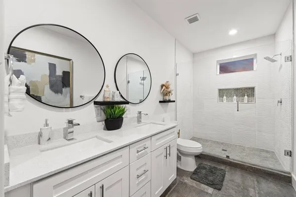 a bathroom with a toilet sink vanity tub and shower