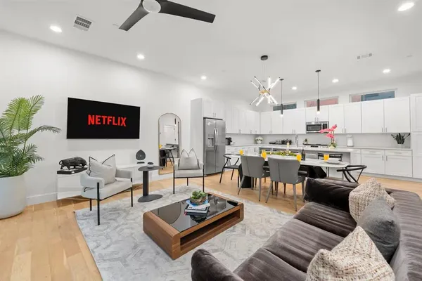 a living room with furniture kitchen view and a potted plant