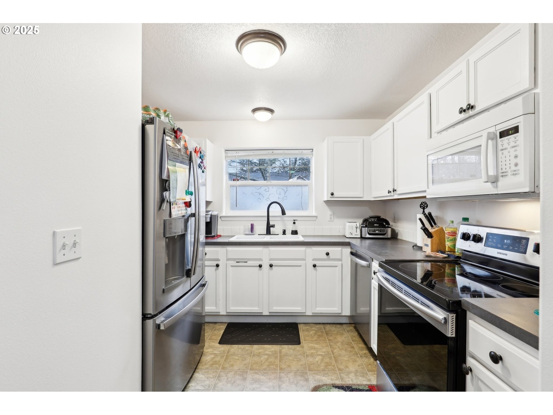 19153 Southeast Yamhill Street, Unit 21 Portland, OR 97233 - Photo 12 of 22 a kitchen with stainless steel appliances granite countertop a sink stove and cabinets